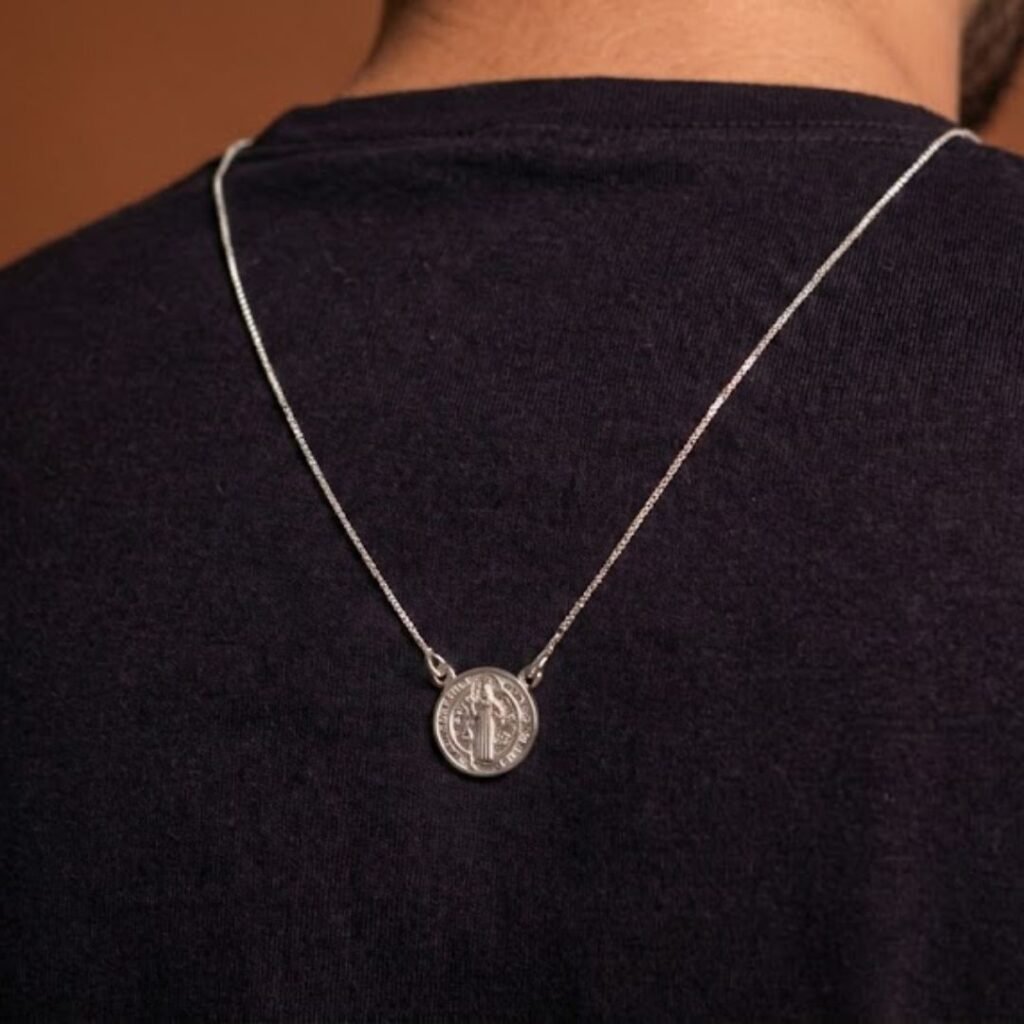Escapulário São Bento em prata 925 usado no pescoço, com a medalha à vista sobre a roupa
