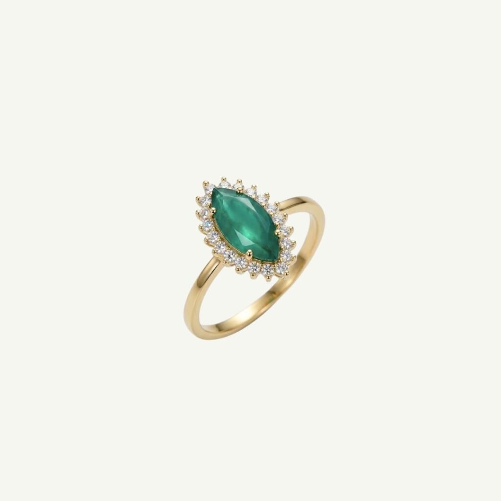 Anel com esmeralda navete em ouro 18k visto de perto, com as marcas internas da pedra, o jardim, visíveis sob o halo de moissanites